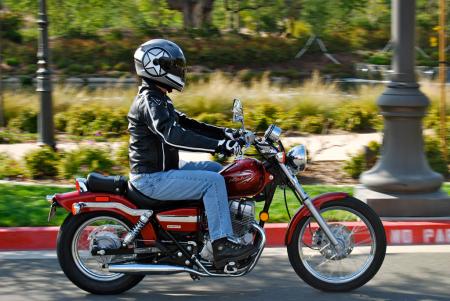 2012 honda rebel review motorcycle com, In this photo the Rebel doesn t look especially small with a rider in the saddle But looks are deceiving Though its ergonomics aren t unbearably tight Pete found its overall fit more suited to smaller riders
