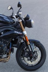 2011 triumph speed triple 1050 review motorcycle com, Sharper steering geometry allows the Speed Triple to initiate turns quicker while the Showa suspension offers a firm yet compliant ride