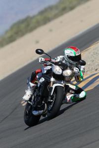2011 triumph speed triple 1050 review motorcycle com, This knee down photo from the racetrack might be a little dramatic but it demonstrates just how capable the S3 is on its side
