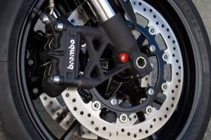 2011 triumph speed triple 1050 review motorcycle com, Brembo calipers provide amazing stopping power Lever feel is precise and it responds well to inputs If you look carefully you ll see an ABS ring on the left rotor a first for the Speed Triple