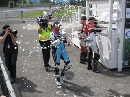 racing electric motorcycles video, At the end of eight hard fought laps I pipped Page for the win in class Spraying the bubbly for you faithful Motorcycle com readers Photo by Jon Connelly