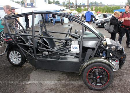 ev live oregon report, Without its bodywork you can see the steel frame of the three wheel Arcimoto While it s considered a motorcycle its ride dynamics are much more like a car