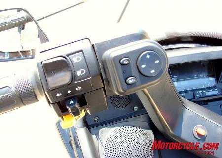 2008 qlink commuter 250 review motorcycle com, Here you can see the speaker covers and the FM MP3 player controls The orange button in the center of the handle bars is the hazard lights button