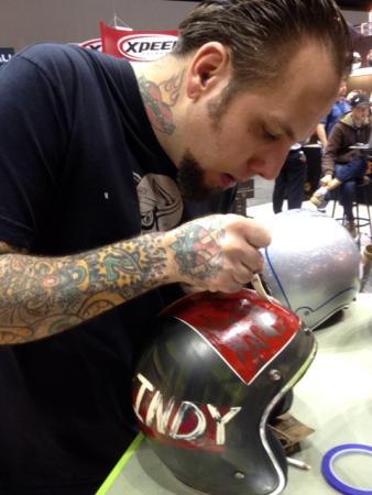 2012 dealer expo, Skratch of Skratch s Garage inks a special Indy open face in the Bell booth Occasionally Bell will convert Skratch s hand drawn custom designs into production helmet color schemes