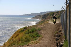 2005 suzuki drz 400 sm motorcycle com, With a hard packed surface and some room to run the SM and I are quickly up to freeway cruising speeds as the waves undulate on one side and the fence waits patiently on the other