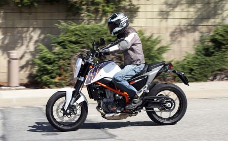 2013 ktm 690 duke review video motorcycle com, The Duke s riding position is comfortably upright and with plenty of legroom but its bucket seat can be confining