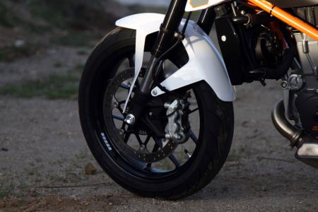 2013 ktm 690 duke review video motorcycle com, The Duke s lack of mass requires only a single disc brake up front the radial mount Brembo providing strong speed retardation Standard equipment is a Bosch ABS unit Thin spoke wheels are new and attractive