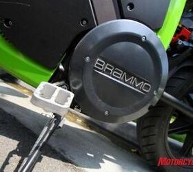2010 brammo enertia review motorcycle com, The air cooled fan plus passive airflow brushless DC motor resides behind this cover No countershaft sprocket just a direct driven 14 tooth sprocket turning a 64 tooth rear for a 4 57 1 final drive ratio