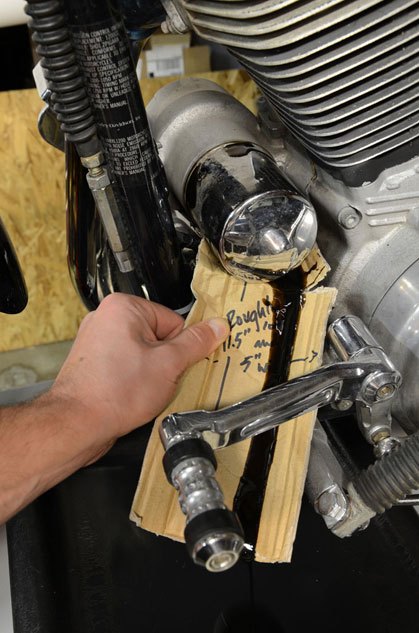 how to change oil in a harley davidson, Place the drain pan underneath the oil filter just in case and the end of the cardboard Unscrew the filter slowly and allow the oil to drain out over the cardboard and into the drain pan