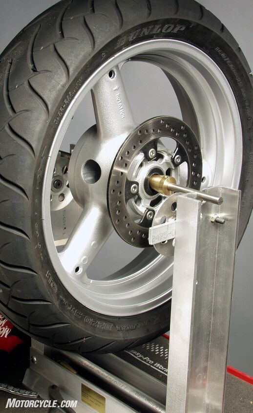 mo wrenching how to balance wheels, The discs on the balancing tool allow the rod supporting your motorcycle wheel to rotate freely giving a more accurate measure Once the wheel stops moving you re ready to temporarily attach the weights to the top of the rim