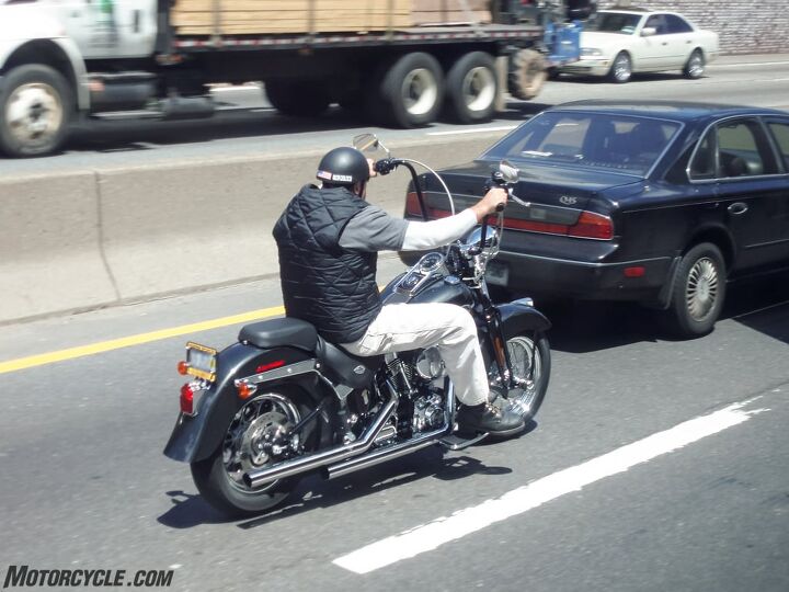 how to ride a motorcycle on the highway safely, Lane splitting along this guy would be way too close to the car ahead but he s actually well positioned in the right of his lane where he can see ahead and where he can move a bit more right to pass the car Note the car has moved left to give him space All he needs now are gloves and a real helmet Open face helmets on the freeway are like having your face sand blasted