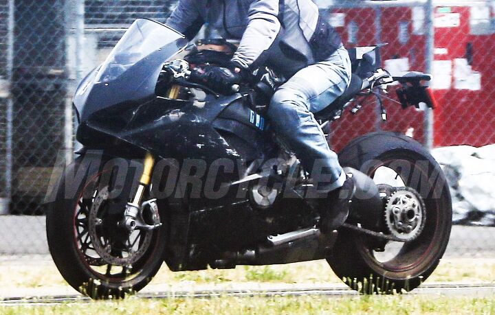 2018 ducati v 4 superbike spy shots motorcycle com, Visible below the Ducati test rider s knee is a rear cylinder not terribly unlike Ducati s traditional V Twin but angled further rearward The added distinction here is that there are a pair of rear cylinders to go along with a pair up front We imagine there will be an aluminum steering head section that doubles as the airbox and engine mount for a monocoque layout similar to the Panigale s An hlins fork and Brembo M50 brakes are predictable