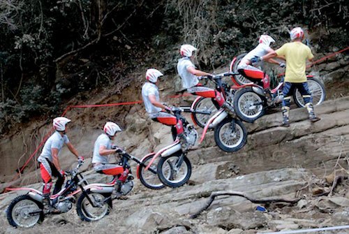 A Trials Rider Leaps up a rockface, completing an obstacle along this outdoor course.