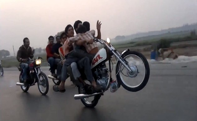 behold the one handed five man motorcycle wheelie