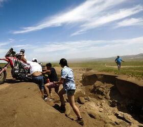 In the middle of Gobi Desert, one rally racer rode so hot into a turn, he failed to notice the deep ravine blending perilously into the horizon. Luckily, a group of fans were there to help him get back on track (literally).