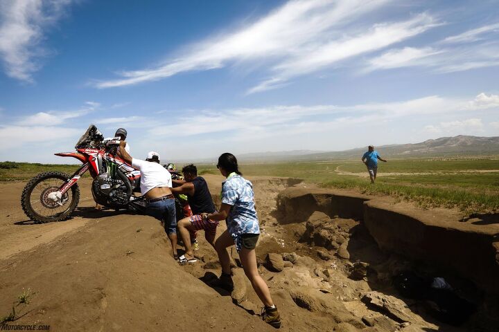 In the middle of Gobi Desert, one rally racer rode so hot into a turn, he failed to notice the deep ravine blending perilously into the horizon. Luckily, a group of fans were there to help him get back on track (literally).