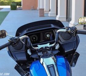 For comparison, the Road Glide’s cockpit features better protection from the elements due to the frame-mounted fairing. The handlebars clearly place your hands in a different position compared to the Street Glide, too. Instead of the drawer underneath the screen, however, the Road Glide features two compartments (one under each speaker) to hold your stuff. The right side cubby has the phone charger in it.