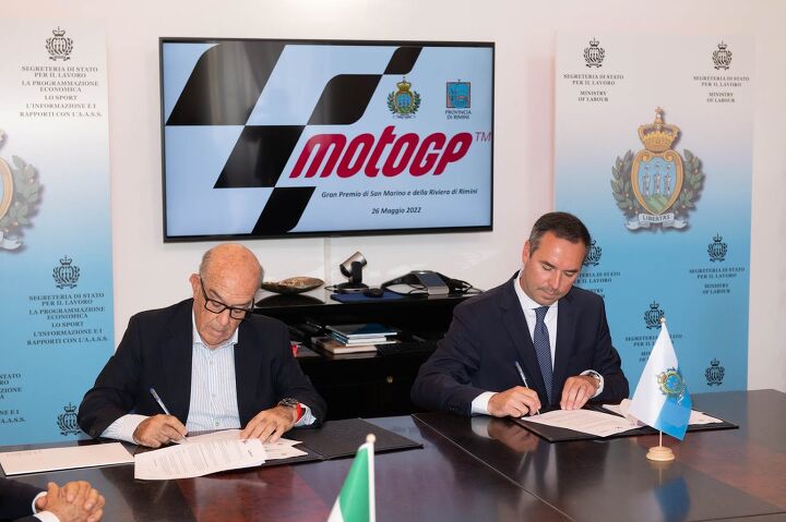 Dorna CEO Carmelo Ezpeleta, pictured in 2022 signing a contract extension for the San Marino Grand Prix.